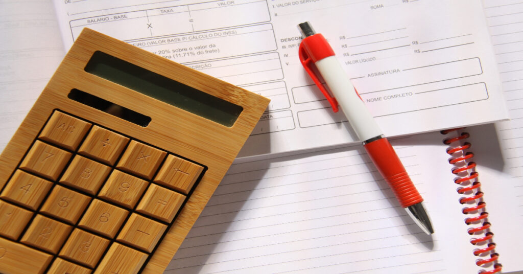 納品書や電卓が並ぶデスクで伝票の種類を整理しているイメージ